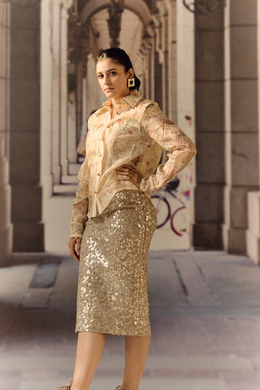 Woman in a gold outfit standing in an urban setting